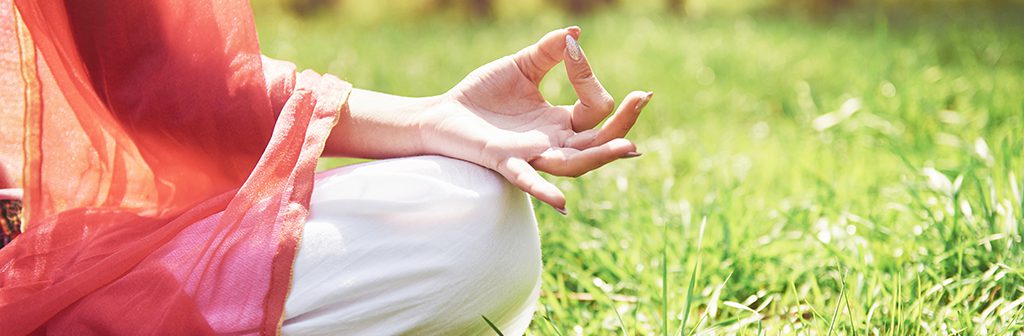 Yoga meditation in a park on the grass is a healthy woman at rest.